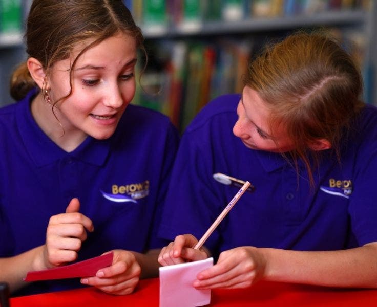 Two girls speaking to each other, planning their debate.