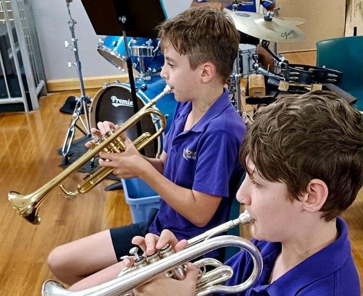 Two boys playing the trumpet