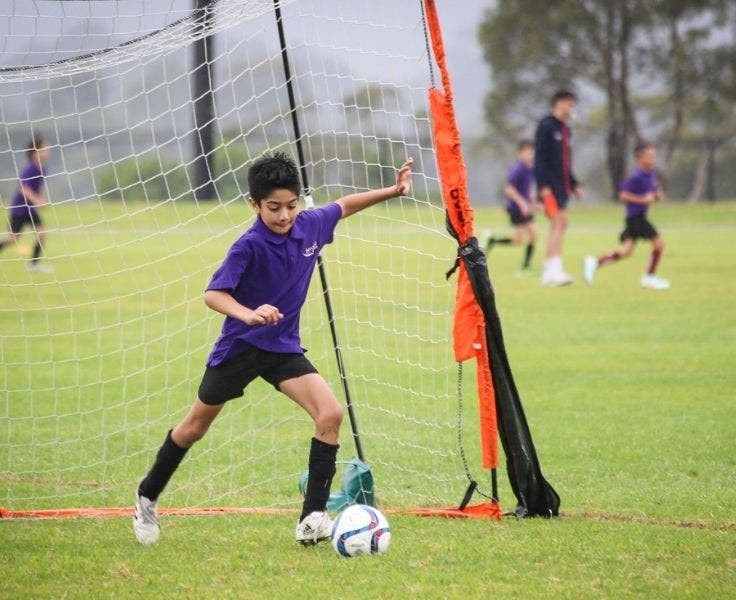 A boy kicking a soccer ball.